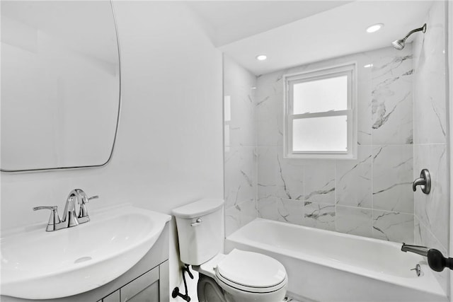 full bathroom featuring vanity, tiled shower / bath combo, and toilet