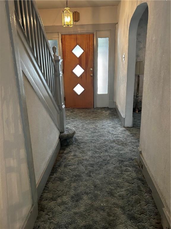 foyer featuring dark colored carpet