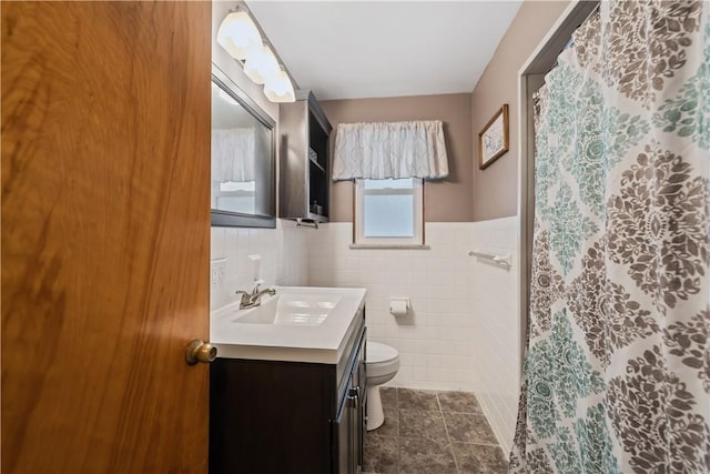 bathroom with vanity, tile patterned flooring, toilet, and tile walls