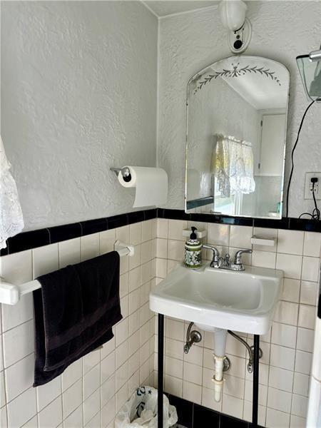 bathroom with sink and tile walls