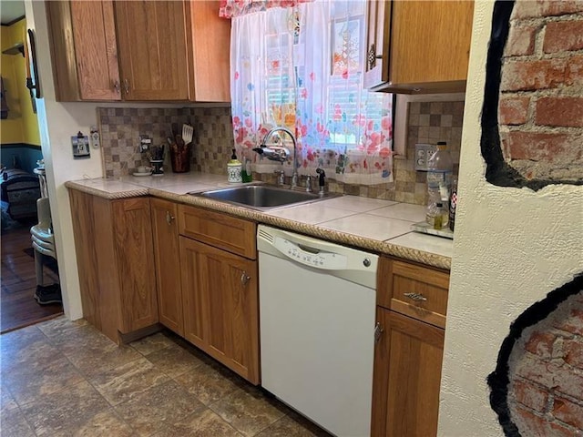 kitchen featuring tasteful backsplash, sink, a healthy amount of sunlight, and dishwasher