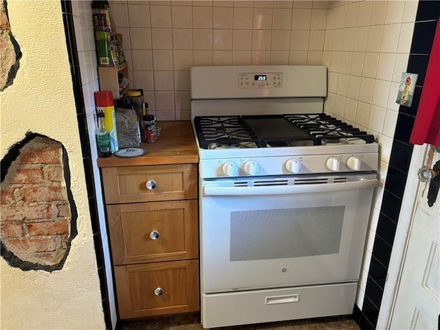 kitchen featuring white range with gas cooktop and decorative backsplash