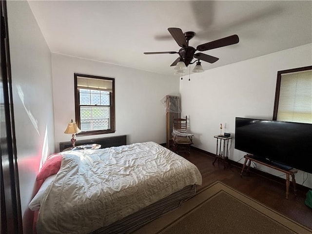 bedroom with dark hardwood / wood-style floors and ceiling fan