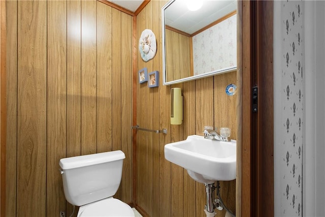 bathroom with toilet and wood walls