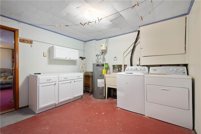 clothes washing area featuring water heater, cabinets, and washer and dryer