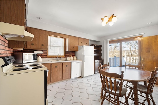 kitchen featuring white appliances, plenty of natural light, sink, and backsplash