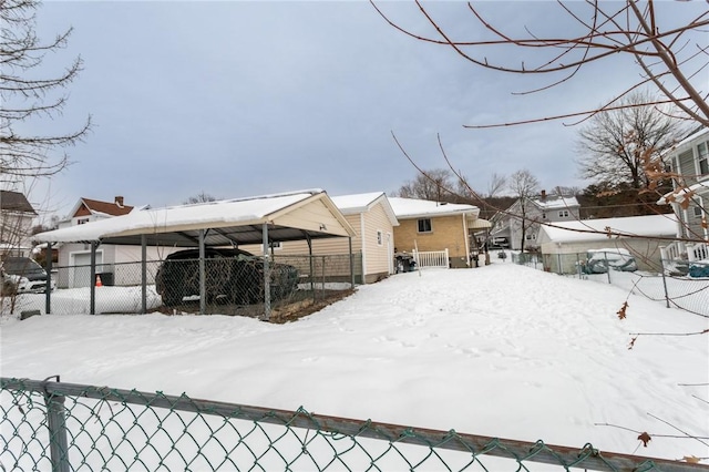 yard covered in snow with a carport