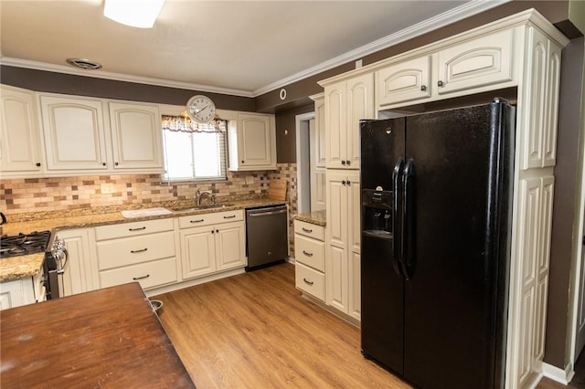 kitchen with appliances with stainless steel finishes, sink, light hardwood / wood-style floors, crown molding, and light stone countertops