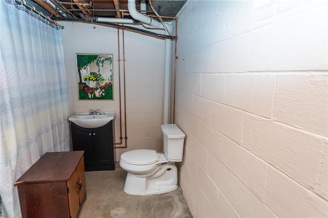 bathroom featuring vanity, concrete flooring, and toilet