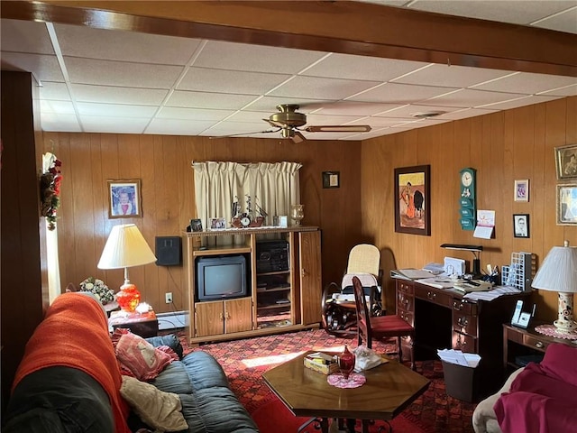 living room featuring a drop ceiling, a baseboard radiator, and ceiling fan