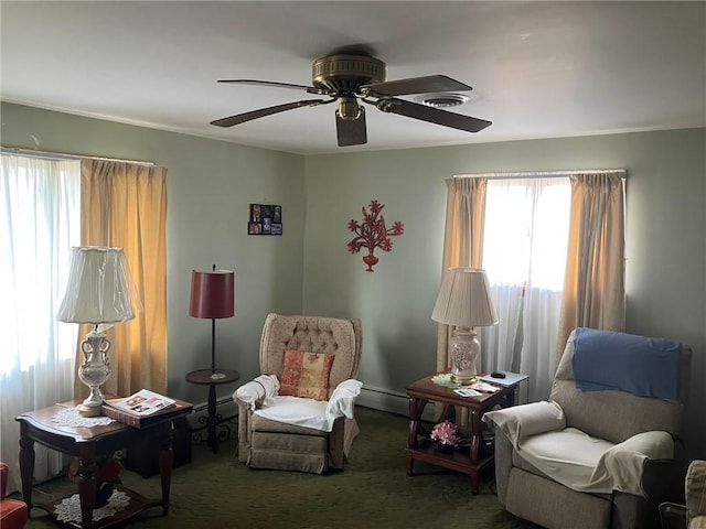 living area with a baseboard radiator, ornamental molding, carpet flooring, and ceiling fan