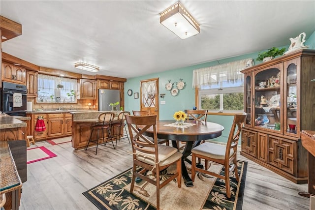 dining room featuring sink and light hardwood / wood-style flooring