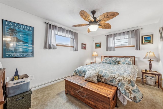 carpeted bedroom featuring a baseboard heating unit and ceiling fan