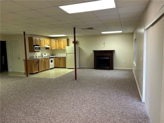 unfurnished living room featuring light carpet and a paneled ceiling