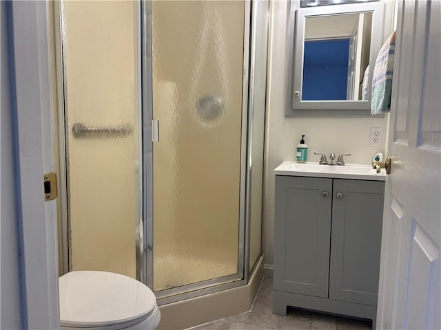 bathroom featuring vanity, tile patterned flooring, a shower with door, and toilet