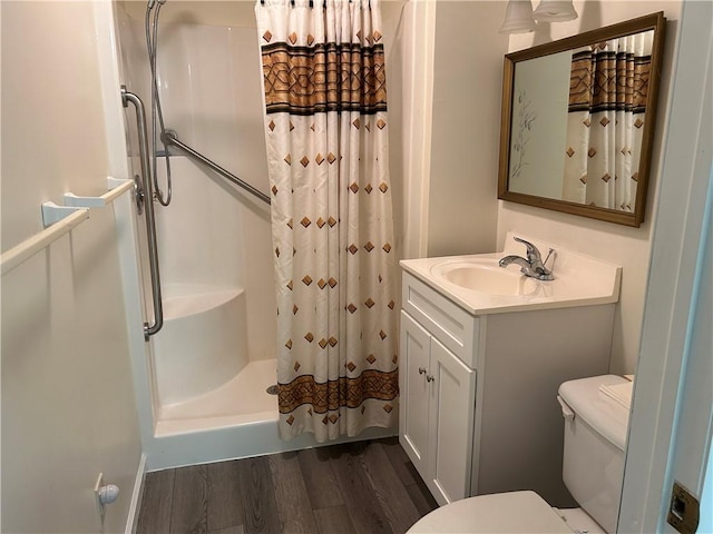 bathroom featuring vanity, hardwood / wood-style flooring, toilet, and walk in shower