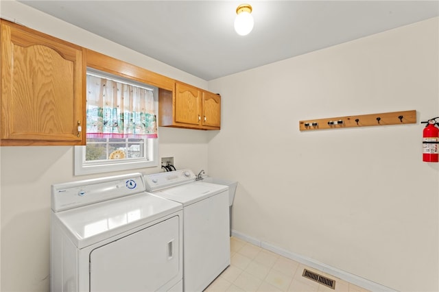 washroom featuring cabinets and washing machine and clothes dryer