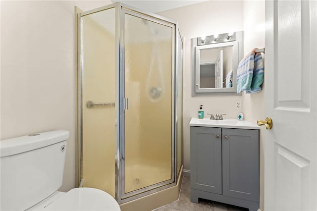 bathroom featuring toilet, vanity, and a shower with shower door