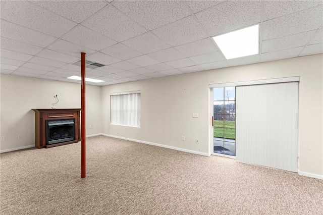 basement featuring a paneled ceiling and carpet flooring