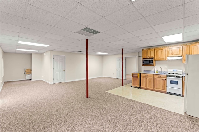 kitchen with sink, light carpet, a drop ceiling, and white appliances