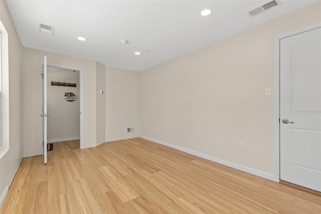 unfurnished bedroom with a walk in closet, a closet, and light wood-type flooring