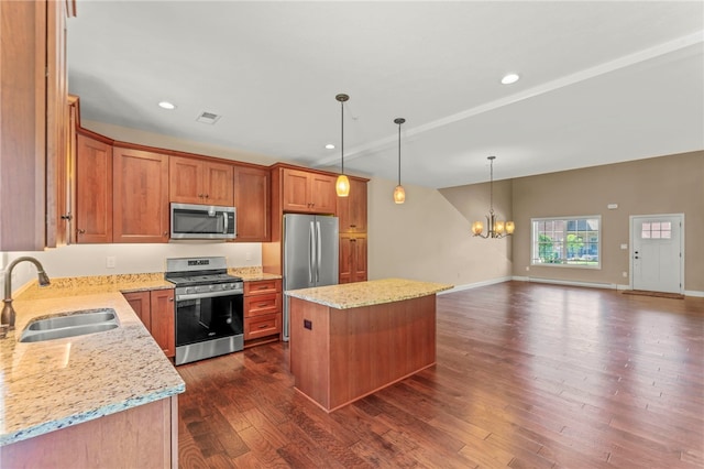 kitchen featuring a kitchen island, appliances with stainless steel finishes, sink, and light stone counters