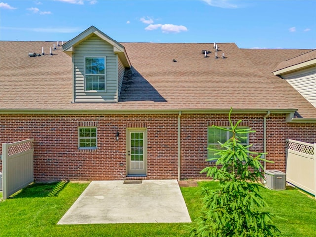 back of property with a lawn, central AC unit, and a patio area