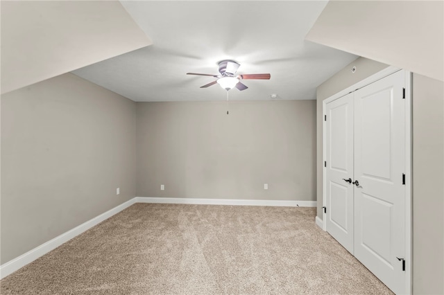 unfurnished bedroom featuring light colored carpet, ceiling fan, and a closet