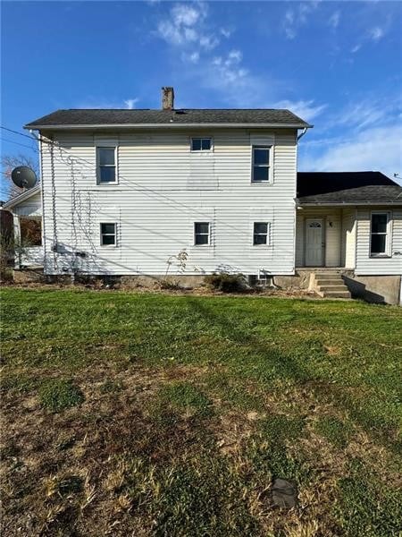 rear view of property with a lawn