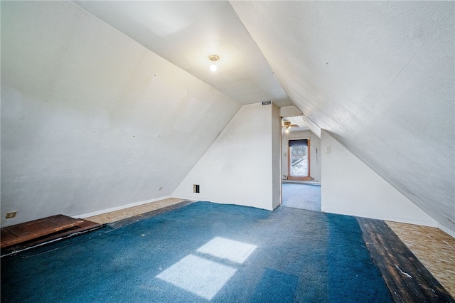 additional living space featuring carpet flooring and vaulted ceiling