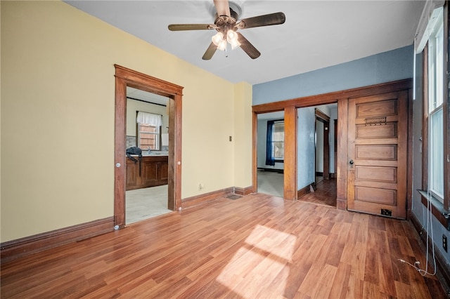 unfurnished bedroom featuring hardwood / wood-style flooring, connected bathroom, and ceiling fan