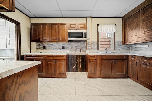 kitchen featuring sink, a paneled ceiling, and decorative backsplash