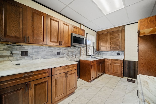 kitchen featuring a drop ceiling, sink, and tasteful backsplash