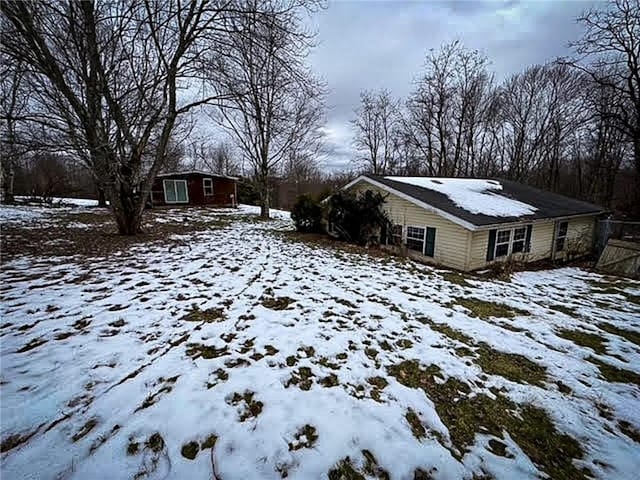 yard covered in snow with a storage unit