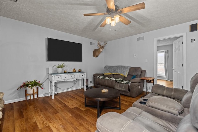 living room with hardwood / wood-style floors, a textured ceiling, and ceiling fan