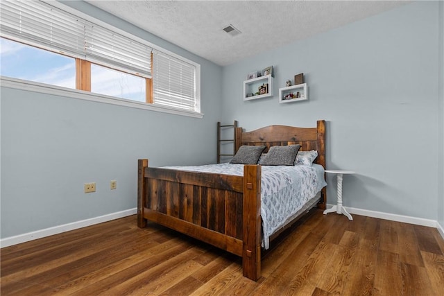 bedroom featuring dark hardwood / wood-style floors and a textured ceiling