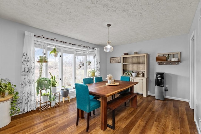 dining space with a textured ceiling and dark hardwood / wood-style flooring