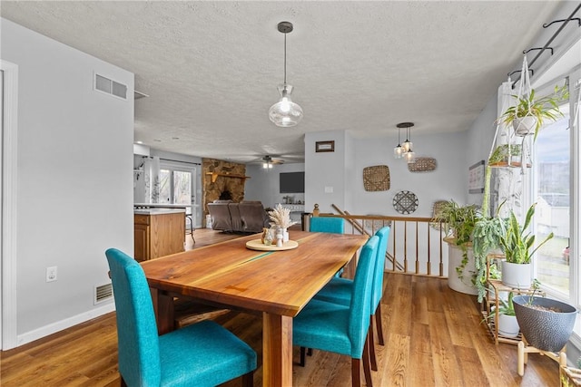 dining area with ceiling fan, a textured ceiling, and light hardwood / wood-style floors