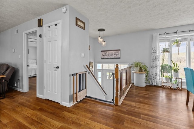 stairway featuring hardwood / wood-style floors and a textured ceiling