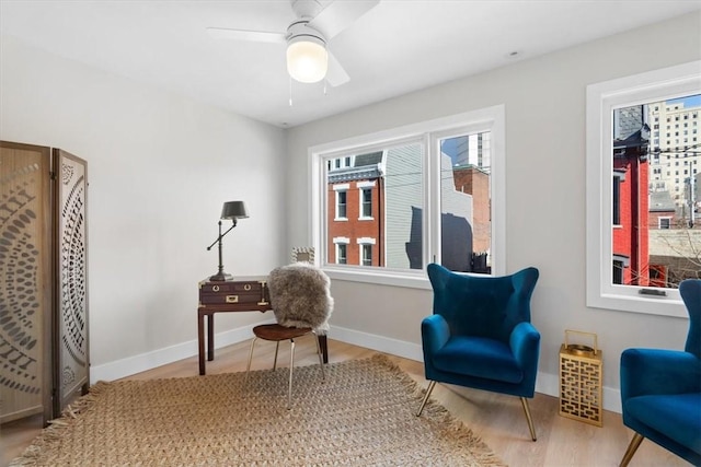 living area with hardwood / wood-style flooring and ceiling fan