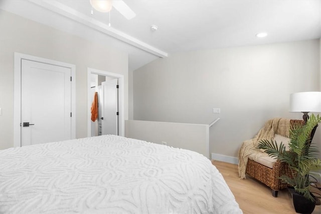 bedroom featuring lofted ceiling with beams, ceiling fan, and light wood-type flooring