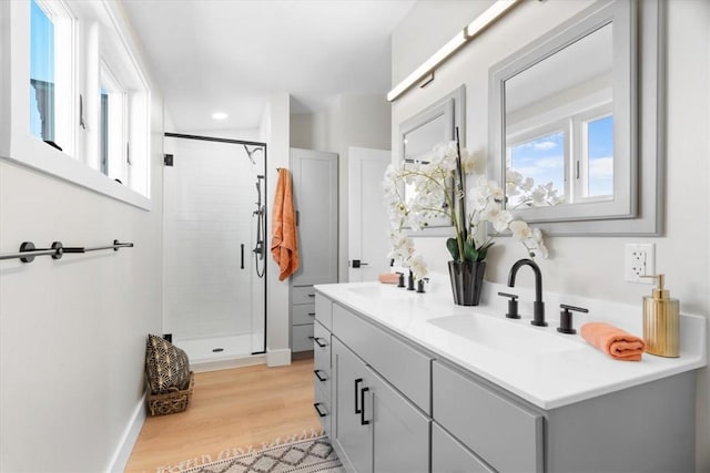 bathroom featuring vanity, a shower with door, hardwood / wood-style floors, and a wealth of natural light