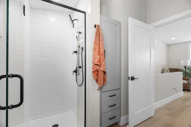 bathroom featuring hardwood / wood-style floors and a shower with shower door