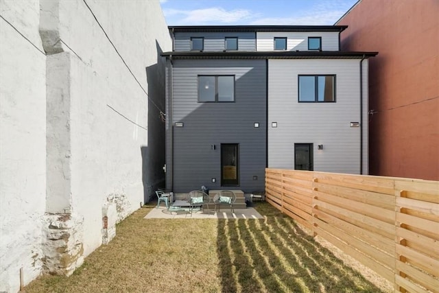 rear view of house with a yard and a patio area