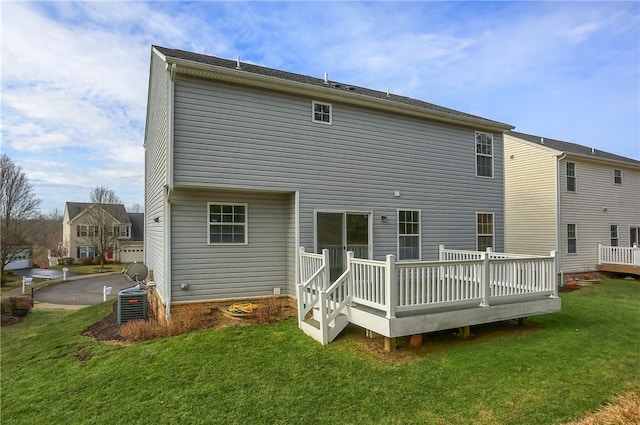 rear view of house featuring central AC, a deck, and a lawn