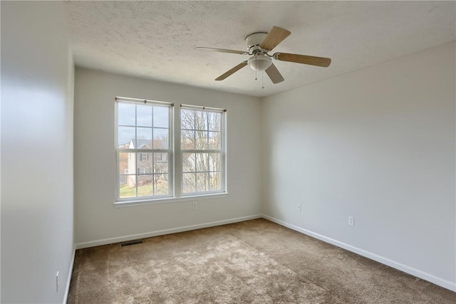 carpeted empty room featuring ceiling fan and a textured ceiling