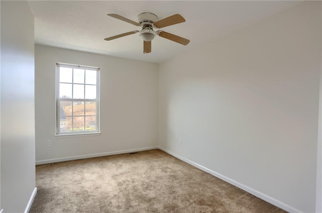 spare room featuring light carpet and ceiling fan