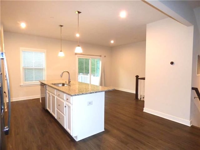 kitchen featuring decorative light fixtures, dishwasher, white cabinets, light stone countertops, and a center island with sink