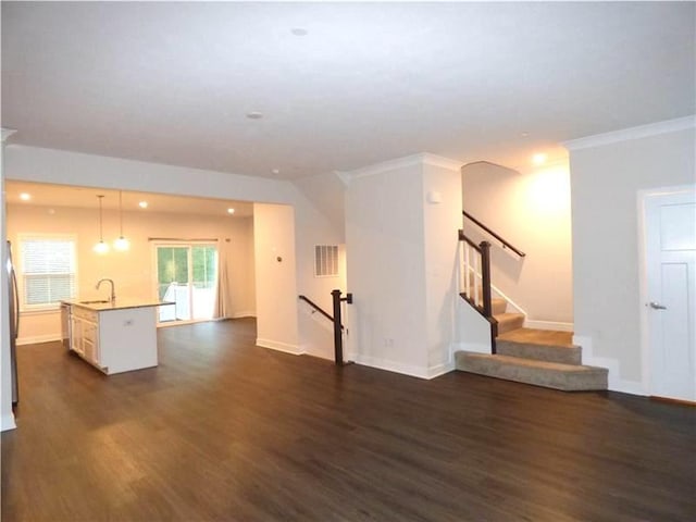 unfurnished living room with crown molding, dark wood-type flooring, and sink