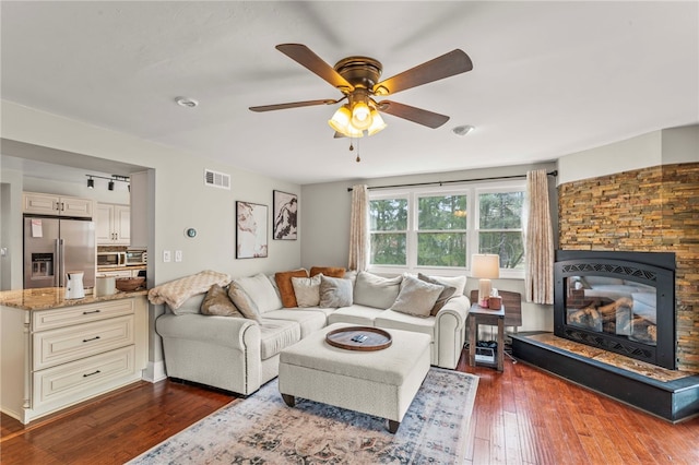 living room featuring dark wood-type flooring and ceiling fan